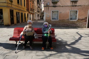 Two women with masks sit on a bench on Good Friday as Italy celebrates Easter under lockdown to try and stop the spread of the coronavirus disease in Venice, April 10, 2020. (Reuters)