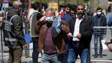 People receive free masks from a municipal worker as the spread of coronavirus disease (COVID-19) continues, in Diyarbakir. (Reuters)