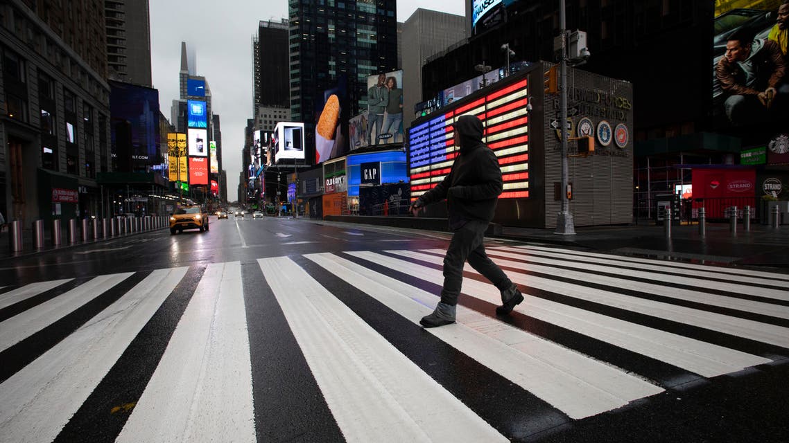 A man crosses the street in a nearly empty Times Square, which is usually very crowded on a weekday morning, Monday, March 23, 2020 in New York. (AP)