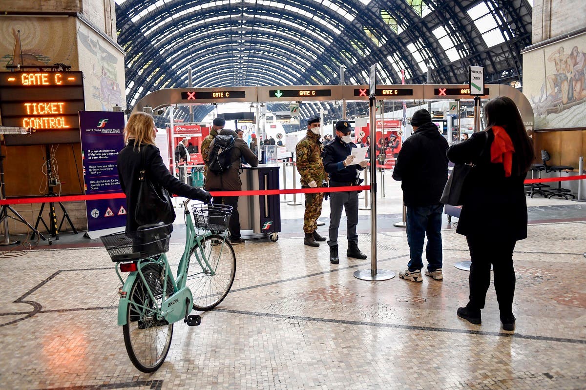 Police officers and soldiers check passengers leaving from Milan main train station, Italy, on March 9, 2020. (AP)