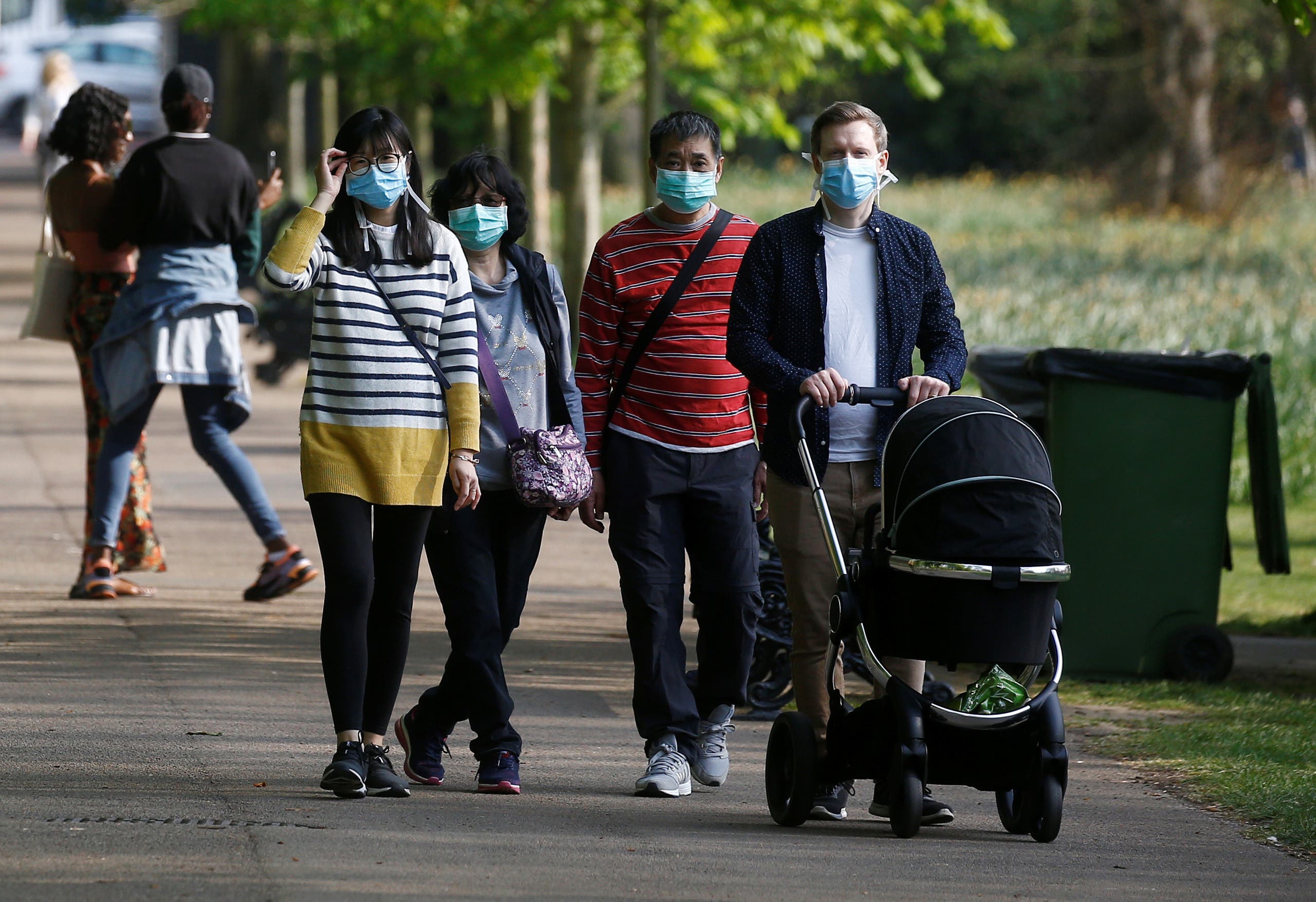 People are seen wearing protective face masks in Greenwich Park as the spread of the coronavirus disease (COVID-19) continues, London, Britain, April 11, 2020. (Reuters)