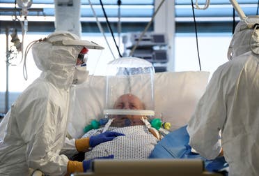 Medical staff members are seen next to a patient suffering from the coronavirus disease (COVID-19) in the intensive care unit at the Circolo hospital in Varese, Italy April 9, 2020. (Reuters)