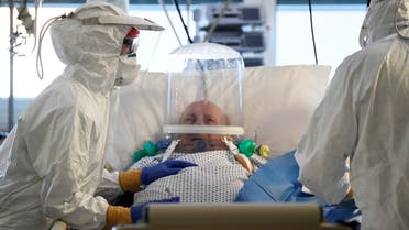 Medical staff members are seen next to a patient suffering from the coronavirus disease (COVID-19) in the intensive care unit at the Circolo hospital in Varese, Italy April 9, 2020. REUTERS/Flavio Lo Scalzo