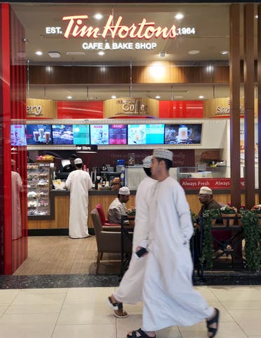 Omani men pass in front of Canadian cafe and bake shop Tim Hortons in City Center Mall in Muscat, Oman. (File photo: Reuters)