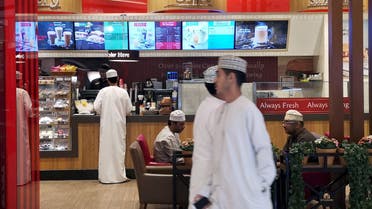 Omani men pass in front of Canadian cafe and bake shop Tim Hortons in City Center Mall in Muscat, Oman, February 11, 2019. (Reuters)