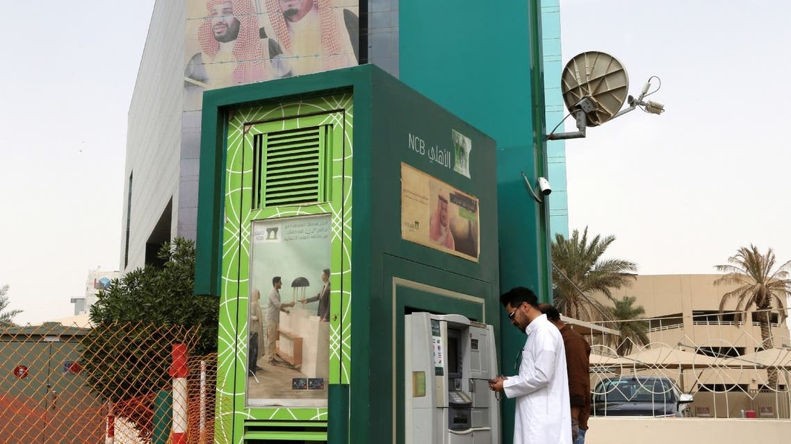 A man withdraws money from an ATM outside the Saudi National Commercial Bank (NCB), after an outbreak of coronavirus, in Riyadh, Saudi Arabia, March 18, 2020. (Reuters)