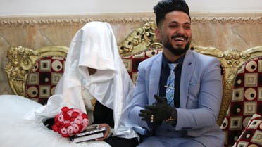 Ahmed Khaled al-Kaabi and his bride Ruqaya Rahim sit during their wedding in Najaf, Iraq, hardest hit town by coronavirus in the country. (AP)