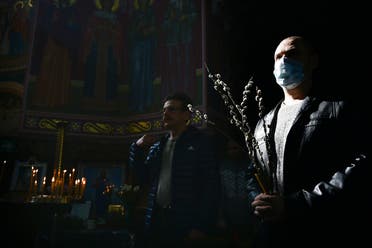 Orthodox Church believers, some wearing face masks to protect from coronavirus, attend a religion service inside a church celebrating Orthodox Palm Sunday in Yevpatoria, Crimea, on April 12, 2020. (AP)