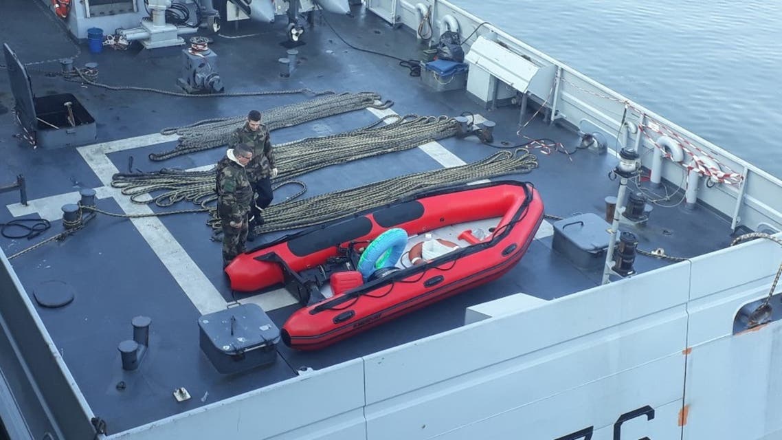 Police officers look at an inflatable boat after they rescued 11 migrants in difficulty who tried to cross the Channel to Great Britain on April 09, 2020 in Calais, northern France, on the twenty-second day of a lockdown in France aimed at curbing the spread of the COVID-19 disease, caused by the novel coronavirus. BERNARD BARRON / AFP