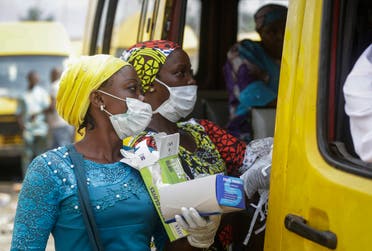 Women sell face masks and gloves, to prevent the spread of the new coronavirus, to passengers at a public minibus station in Lagos, Nigeria on Friday, March 27, 2020. (AP)