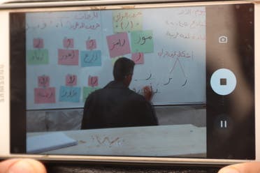 Teachers film and stream an Arabic language lesson in Kahatein camp in Harbanoush, Syria. (Muhammad Al Hosse)