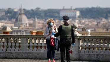 A carabineri police officer talks to a woman wearing a face mask at the Gianicolo hill overlooking Rome, on April 13, 2020. (File photo: AP)