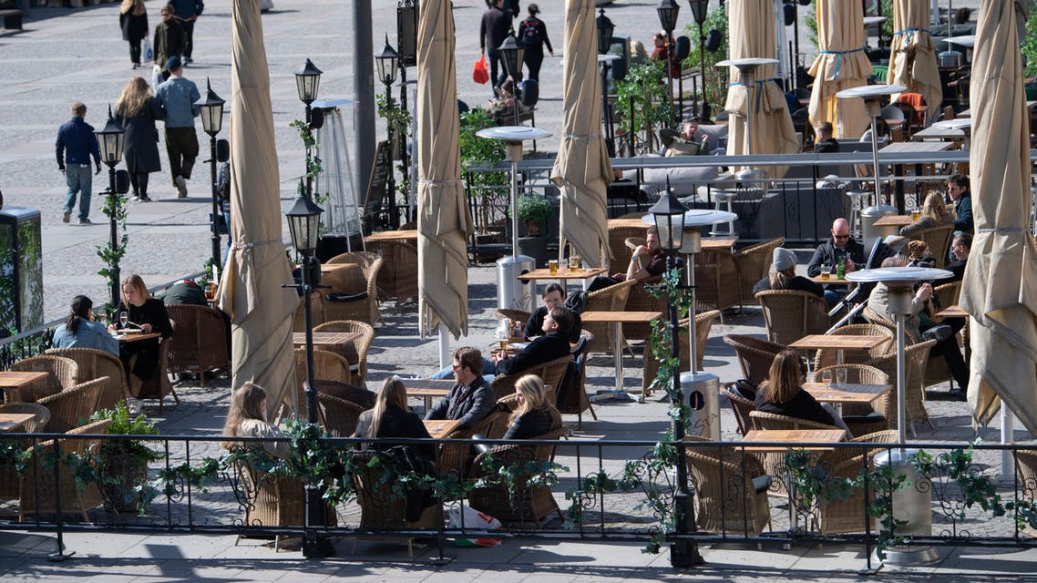 People sit at a cafe terrasse in central Stockholm, Sweden, on April 11, 2020 amid the new coronavirus COVID-19 pandemic. afp