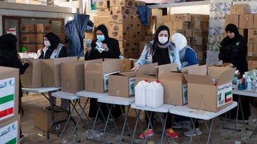 Kuwaiti volunteers wear protective masks as they fill charity boxes with essential household supplies to distribute to the needy, following the outbreak of the coronavirus disease (COVID-19), in Adeliah, Kuwait April 4, 2020. Picture taken April 4, 2020. REUTERS/Stephanie McGehee