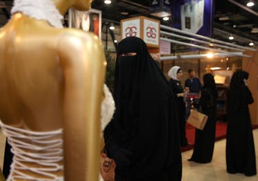 A woman walks past a wedding dress on display at The Bride Show in Dubai, United Arab Emirates. The event, for the wedding industry, is held for four days in Dubai. (File photo: Reuters)