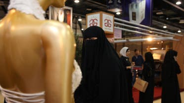 A woman walks past a wedding dress on display at The Bride Show in Dubai, United Arab Emirates. The event, for the wedding industry, is held for four days in Dubai. (Reuters)