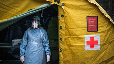 A medical staffer at Sophiahemmet hospital stands at the entrance of a tent for testing and receiving potential coronavirus COVID-19 patients on April 7, 2020 in Stockholm.