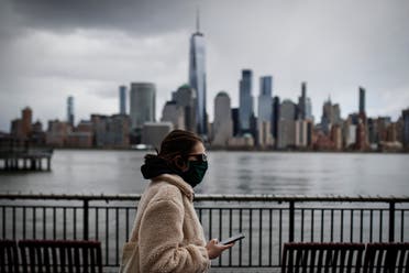  The downtown New York City skyline looms over pedestrians wearing masks due to coronavirus concerns, on Friday, April 10, 2020, in Jersey City, N.J. (AP)