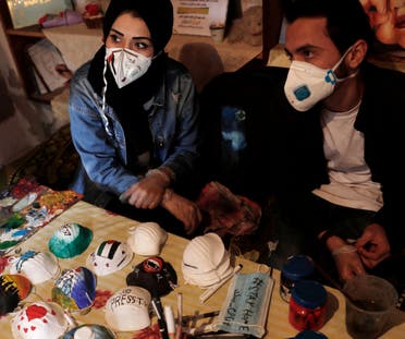 Palestinian artists Dorgham Qeraqea, left, and Samah Saed decorate protective face masks to encourage people to wear them as a precaution against the coronavirus, at a workshop in the Shijaiyah neighborhood of Gaza, Thursday, April 2, 2020. (AP)
