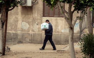An Egyptian man carries a box with foodstuffs outside a center of non-governmental organization Egyptian Food Bank on April 05, 2020. (AFP)