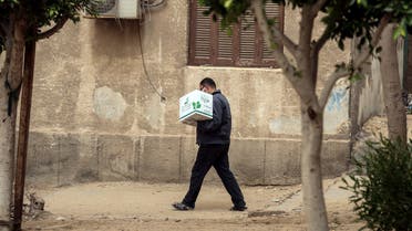 An Egyptian man carries a box with foodstuffs outside a centre of non-governmental organisation Egyptian Food Bank on April 05, 2020. (AFP)