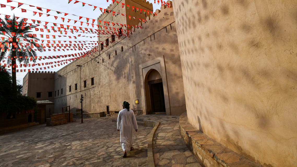 a man walking past the walls of the Nizwa Fort in Oman. (AFP)