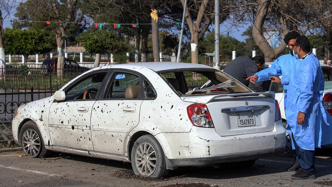 Medics inspect a damaged car at the parking lot