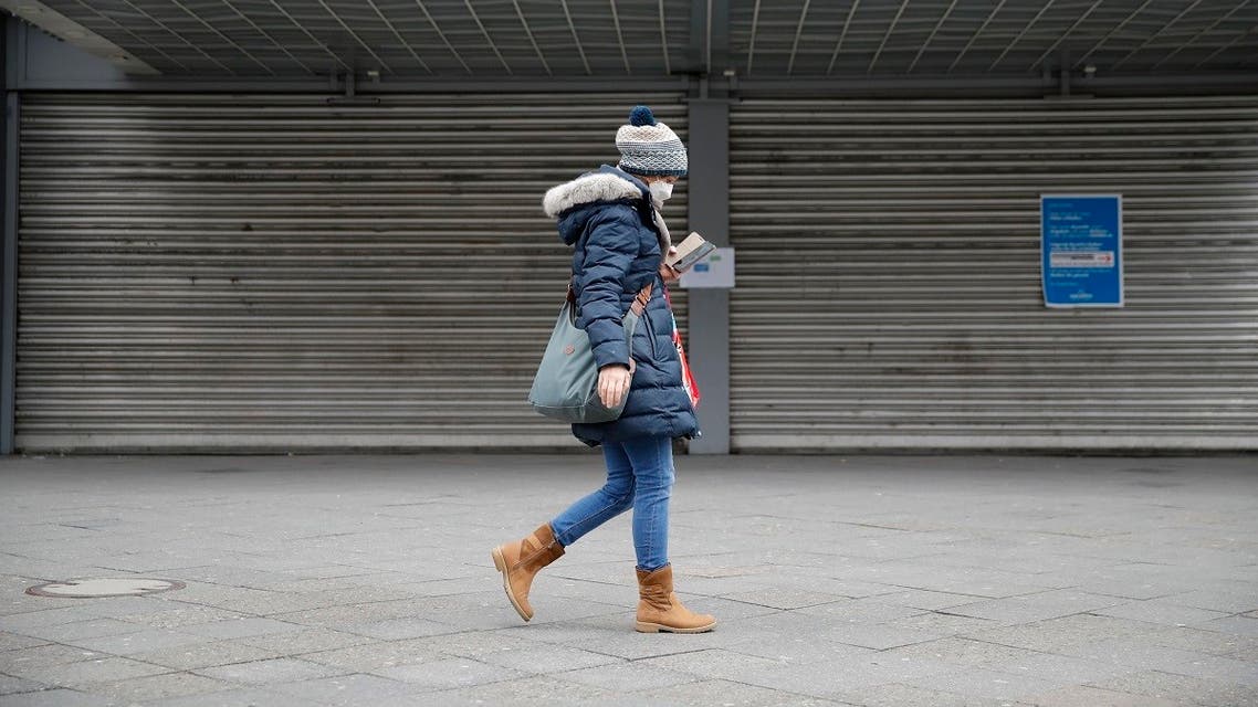 A woman wearing a face mask to limit the spread of the novel coronarivurs walks past a department store of German retail chain Karstadt of the Galeria Karstadt Kaufhof group on April 2. (Reuters)