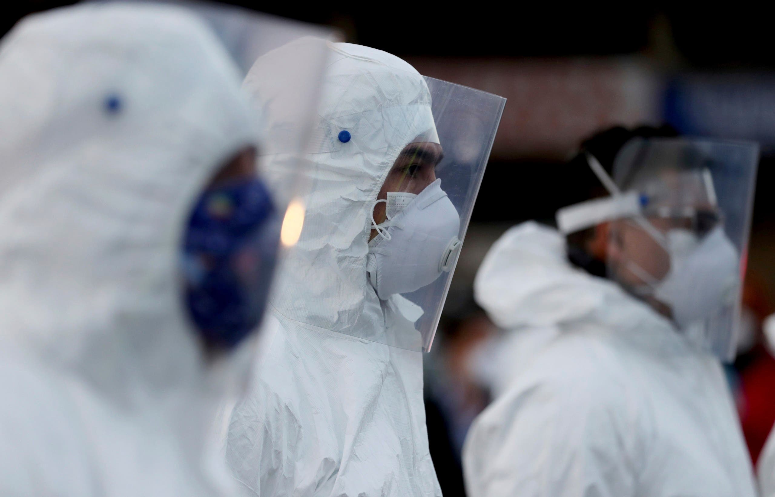 Workers wearing a protective suits stand ready to clean at Corabastos, one of Latin America's largest food distribution centers, in an effort to contain the spread of the new coronavirus in Bogota, Colombia on April 10, 2020. (AP)