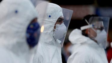  Workers wearing a protective suits stand ready to clean at Corabastos, one of Latin America's largest food distribution centers, in an effort to contain the spread of the new coronavirus in Bogota, Colombia on April 10, 2020. (AP)