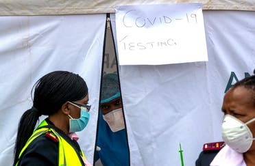 A health worker wearing personal protective gear inside a testing tent, gestures colleagues during the screening and testing for COVID-19, in Lenasia, south of Johannesburg, South Africa on April 8, 2020. (AP)