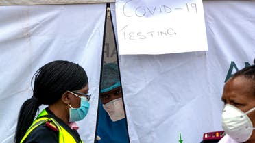 A health worker wearing personal protective gear inside a testing tent, gestures colleagues during the screening and testing for COVID-19, in Lenasia, south of Johannesburg, South Africa on April 8, 2020. (AP)