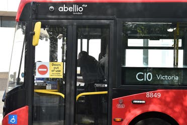 A sign reading “Doors out of use” is pictured on the front doors of a Transport for London (TfL) bus operated by Abellio, as customers are made to use the middle doors in an effort to keep the driver safe. (AFP)