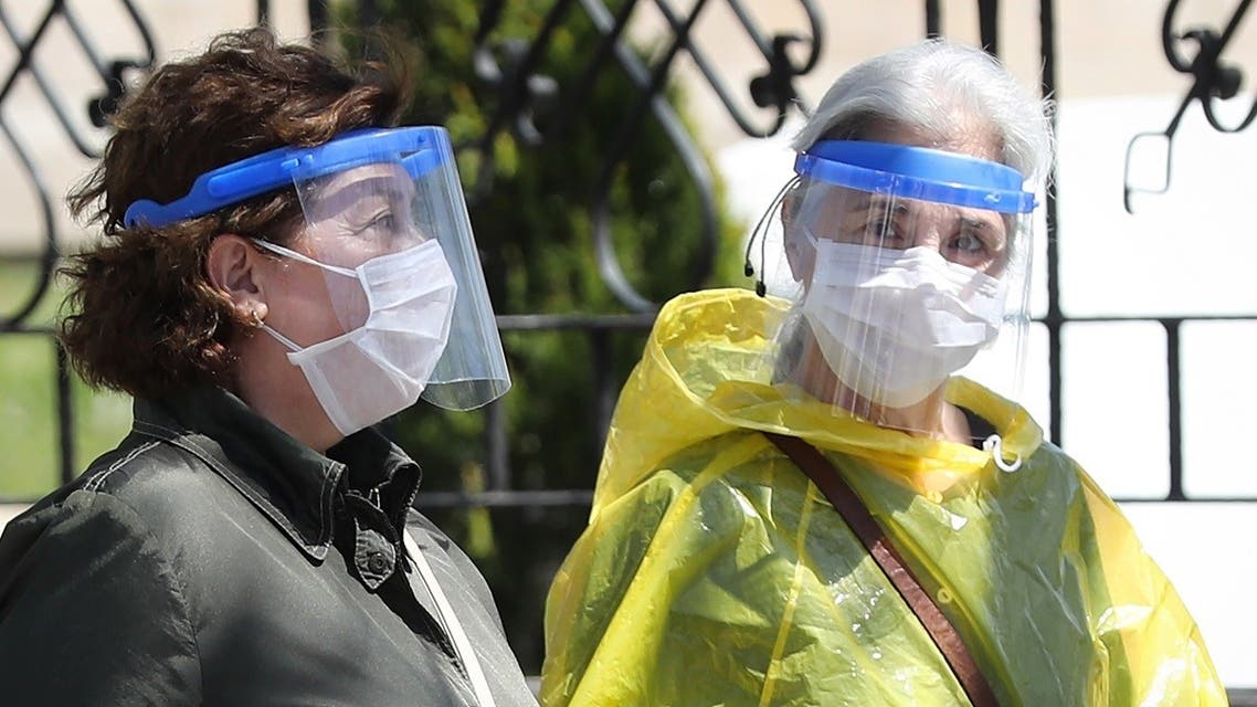 Two women wearing protective facemasks and face-shields, speak together as they walk in the streets of Ankara. (AFP)
