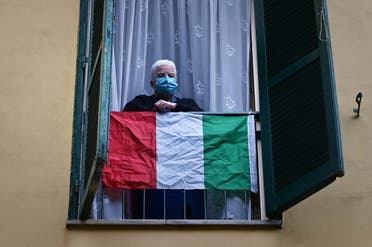 مسن إيطالي يطل من النفاذة في روما مرتدياً كمامة
