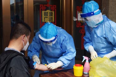 A medic draws blood from a man to conduct a test for antibodies against the coronavirus in Suifenhe, a city in China's Heilongjiang province, April 16, 2020. (Reuters)