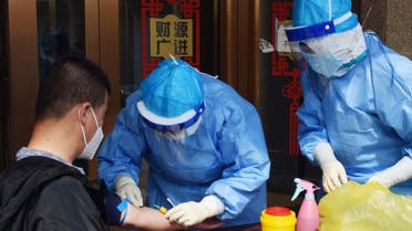 A worker from the city's center for disease control and prevention draws blood from a man to conduct a test for antibodies against the coronavirusin Suifenhe, a city in China's Heilongjiang province, April 16, 2020. (Reuters)
