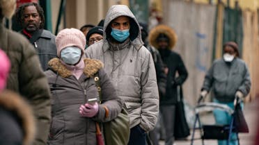 People wearing protective masks wait in line for free masks and pre-packaged meals during the outbreak of the coronavirus disease (COVID-19) in New York City, U.S., April 18, 2020. REUTERS/Jeenah Moon