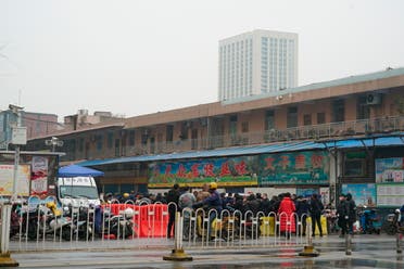 People gather outside the Wuhan Huanan Wholesale Seafood Market, where a number of people related to the market fell ill with COVID-19 in Wuhan, China, on January 21, 2020. (Reuters)