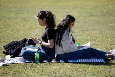 Letitia Klos, left, and her roommate Aesha Patel, both students at Boston University Dental School, spend time in The Public Garden in Boston, Friday, on March 27, 2020. (AP)