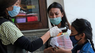 A medical staff checks the temperature of a girl at the entrance of Oking Hospital in Kohima, capital of the northeastern Indian state of Nagaland, Monday, April 13, 2020 (AP)
