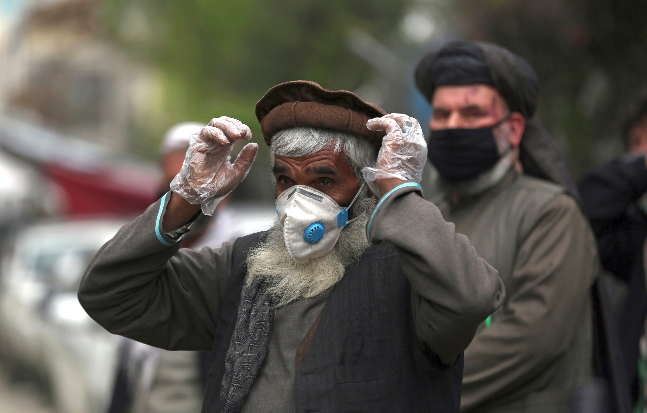 Daily-wage workers wear a protective face mask to help curb the spread of the coronavirus in Kabul, Afghanistan, April 20, 2020. (AP)
