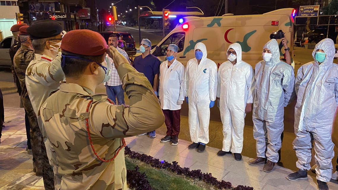 Iraqi Army officers salot to a group of doctors and midecal staff in solidarity with the families of those who have died or are ill with the coronavirus and support for doctors and nurses fighting to save them, in central Baghdad, Iraq on April 7, 2020. (AP)