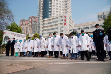 Medical workers bow their heads during a national moment of mourning for victims of coronavirus in Wuhan in central China's Hubei Province on April 4, 2020. (AP)