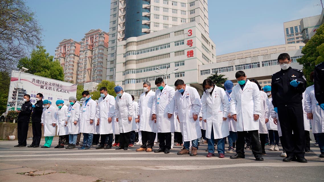 Medical workers bow their heads during a national moment of mourning for victims of coronavirus in Wuhan in central China's Hubei Province on April 4, 2020. (AP)