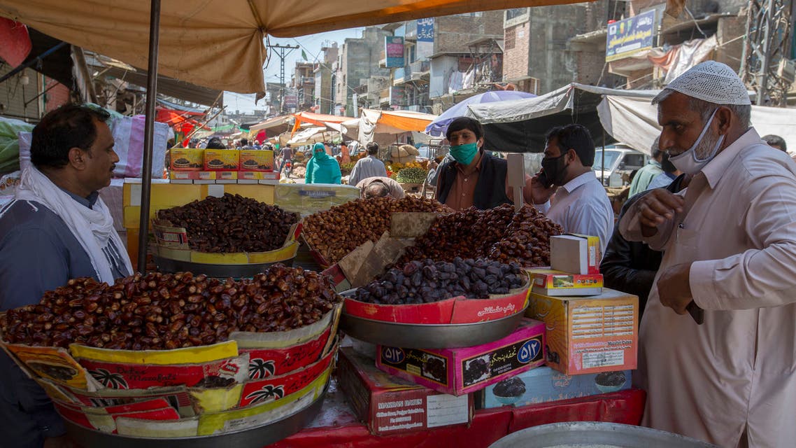 Consumers buy dates for the upcoming fasting month of Ramadan, during a lockdown to contain the spread of coronavirus, in Rawalpindi, Pakistan, on Tuesday, April 21, 2020. (AP)