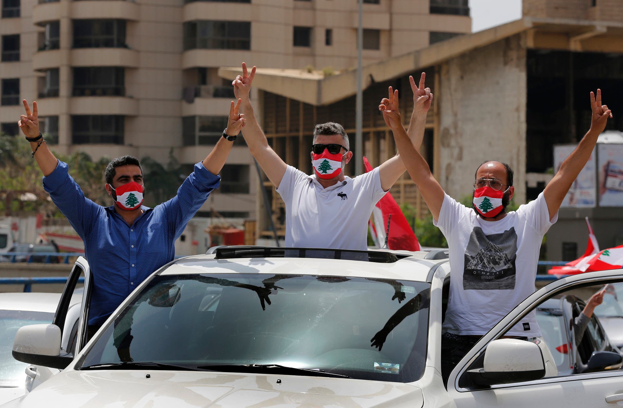 Anti-government protesters flash the victory sign during a driving convoy protest through the streets to express rejection of the political leadership they blame for the economic and financial crisis, in Beirut, Lebanon, on Tuesday, April 21, 2020. (AP)