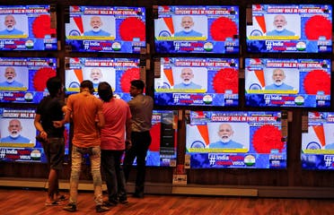 People watch Indian Prime Minister Narendra Modi addressing the nation amid concerns about the spread of coronavirus disease, on TV screens inside a showroom in Ahmedabad, India, on March 19, 2020. (Reuters)