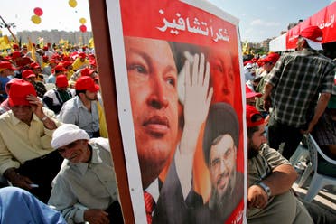 Hezbollah supporters carry a banner showing Hezbollah leader Hassan Nasrallah and Venezuela's then-President Hugo Chavez in Beirut's suburbs on Sept. 22, 2006. (AP)