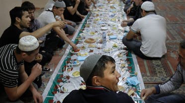 Migrant workers sit for a meal after prayers on the first day of Ramadan in a mosque in Moscow. (Reuters)